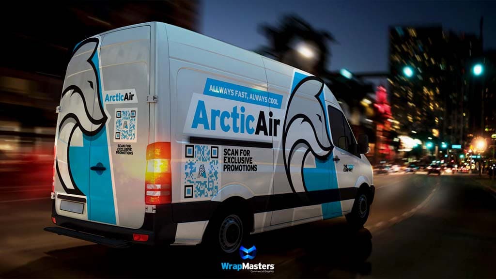 ArcticAir van wrap with scan-for-promotions QR codes driving through downtown Denton at night, a WrapMasters commercial wrap