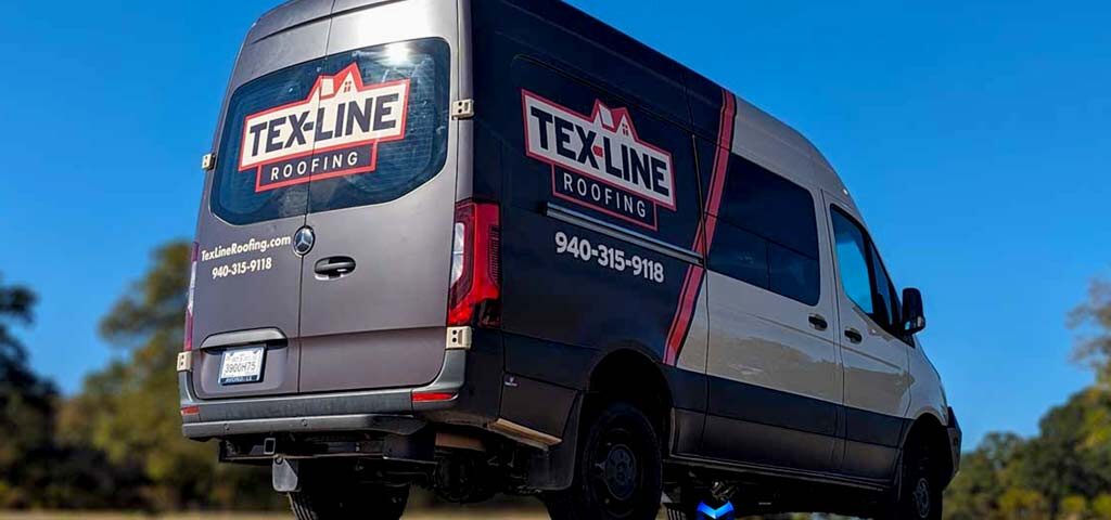 Black commercial van with red and white "TEX-LINE Roofing" custom wrap design parked outdoors under clear blue sky, with contact number displayed and a suburban backdrop