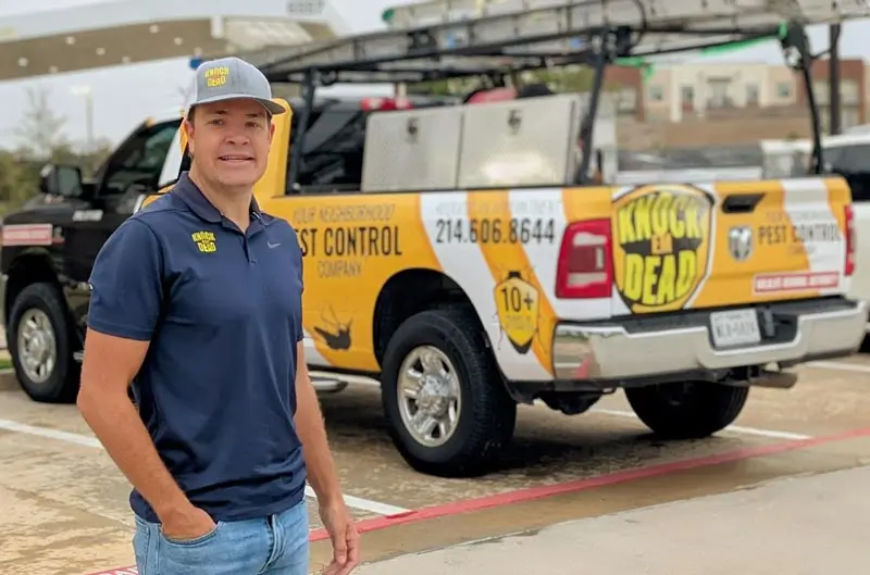 pest control business owner standing in front of branded service truck used for daily work